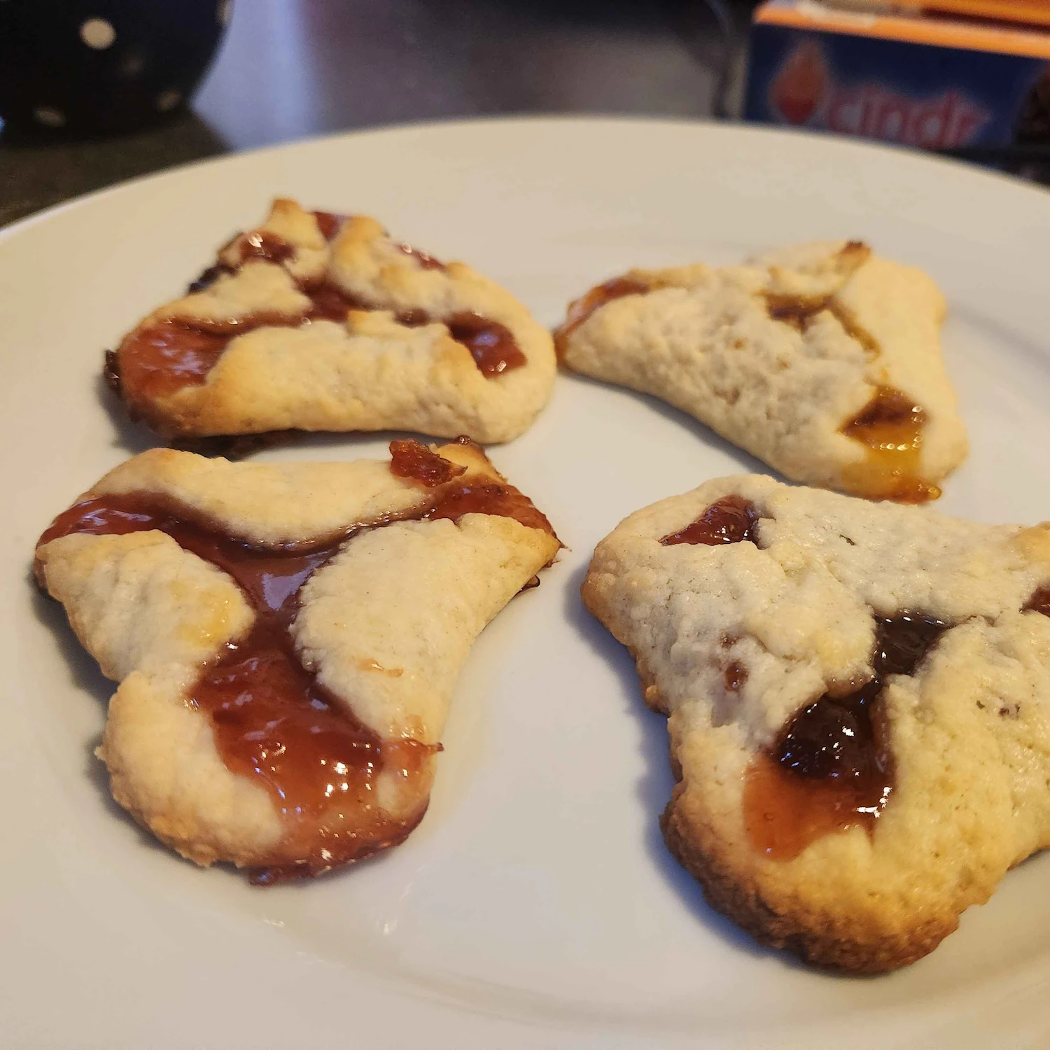 Four super flat jelly tarts on a plate.